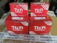 Four red TOR Steering & Suspension branded boxes stacked on a table, showing the packaging condition and branding.