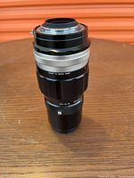 Side profile and mount of the Nikon Nikkor-Q 200mm f/4 lens showing minor wear on the body and mount.