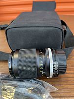 Zoom-Nikkor 35-105mm lens with carrying case, front lens cap, and USB cable.
