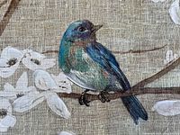 Close-up of the blue bird with blue and green coloration perched on a dogwood branch with white flowers on canvas.