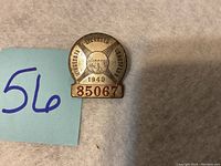 Front view photo of the 1940 Minnesota Licensed Driver Chauffeur pinback badge with visible badge number 85067.