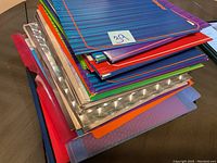 Stack of assorted folders showing various colors and materials