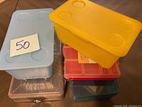 Photo showing stacked plastic storage containers in yellow, blue, red and clear.