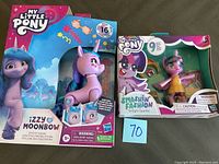 Front view of boxed Izzy Moonbow doll and Smashin' Fashion Twilight Sparkle doll showing packaging and characters