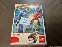Front view of the Lego Robo Champ board game box sealed in plastic with a blue sticker showing number 12.