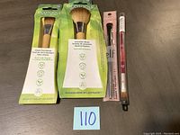Photo of four new make-up items: Ecotools classic foundation brush, precision blush brush, e.l.f. lip exfoliator brush, and dual-ended lip liner pencil on grey surface with lot number.
