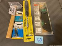 Photo showing all items including hammer, two packages of hooks, Stanley push drill, and universal level.