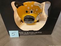 Front view of yellow NFL piggy bank in box showing face and ears.