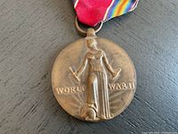 Close-up of front side of World War II Victory Medal with visible figure and inscription 'WORLD WAR II'.