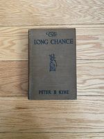 Front cover of The Long Chance book showing the title, author, and small central illustration on the brown cloth cover.