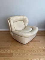 Three-quarter front view showing overall shape, upholstery, and metal feet