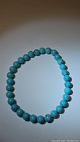 Turquoise stretchy bracelet laid flat showing round robin's egg blue beads with natural veining, approximately 6mm beads.