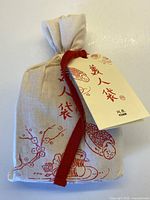 Cotton drawstring bag with Yuan branding and attached tag