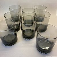 Eight smoky grey glasses arranged upright