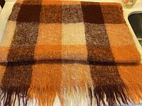 Folded Glen Cree mohair blanket showing full plaid pattern and fringe