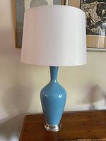 Full view of lamp with shade on wooden surface