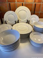 Stacked white ribbed dinnerware showing plates and bowls