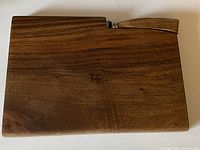 top view of walnut cheese board with knife inserted