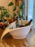 Overall view of white ceramic ice bucket holding wine bottles
