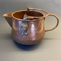 Full view of copper watering can showing shape, spout, bail handle, and patina