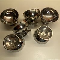 Five stainless steel footed bowls grouped together