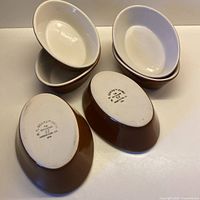 Six oval ramekins, three showing interiors and three showing exteriors