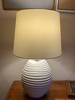 Full view of lamp lit, showing shade and ceramic body