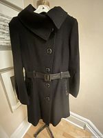 Front view of black wool Mackage coat showing buttons, belt, pocket trims