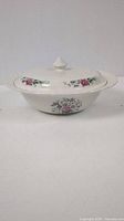 White china serving bowl with floral decoration and lid, front angle view.