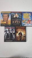 Five DVDs including The Patriot, Angels & Demons, High School Musical Extended Edition, Lawless, and I Am Legend Widescreen Edition arranged in a grid on a white background.