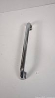 Chrome shower or bathtub safety grab bar with curved design, viewed vertically in the first image showing mounting holes.
