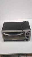 Front angled view of Black & Decker toaster oven showing control knobs and door handle.