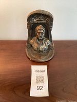 Front view of the bronze Dante bookend showing the bust and decorative top arch.