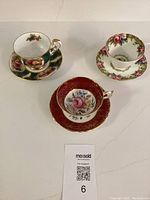 Photo showing three Paragon teacups and saucers arranged on a white marble surface illustrating their size, pattern, and condition.
