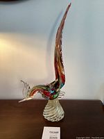 Full side view of multicolored glass pheasant on spiral base