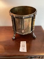 Full view of the brass cachepot planter showing its size and design on a wooden surface.