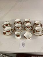 Full set of 8 cups and saucers along with creamer and sugar bowl laid out on counter