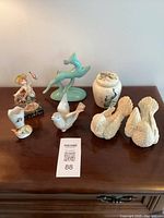 Photo of 7 vintage ceramic and porcelain collectibles arranged on wooden surface