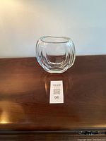 Clear vintage signed Orup Johansfors crystal vase displayed on wooden surface. Shows front view with rounded, bulbous shape and vertical ridges.