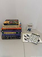 Another angle of the book stack with clearly visible book titles across various subjects related to nature and gardening.