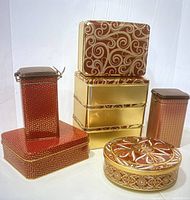 All eight tins arranged with rectangular, tall square, and round tins showing red and gold holiday designs