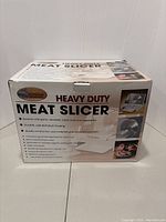 Box front showing branding, features and specifications of the meat slicer.