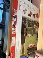 Box showing the bean bag toss set with people playing outside and detailed illustrations of the product features and packaging.