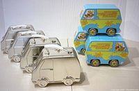 Six tin containers: three silver camper vans and three colorful Scooby-Doo Mystery Machine vans stacked