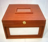 Front view of one wooden box showing frosted panel, brass latch, and top rectangular framed handle