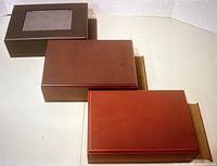 Three wooden boxes placed side by side showing different top finishes including a transparent window on one box.