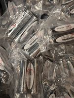 Photo shows multiple individually wrapped Universal Power AA batteries in clear plastic bags, scattered closely.