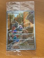 Front view of sealed Mimikyu promo card in original plastic wrap showing card design and details.