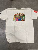 Front view of the white Nintendo shirt with colorful Mario characters graphic and Nintendo logo on sleeve.