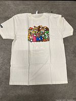 White XL T-shirt laid flat on carpet with colorful Nintendo character graphic on front.